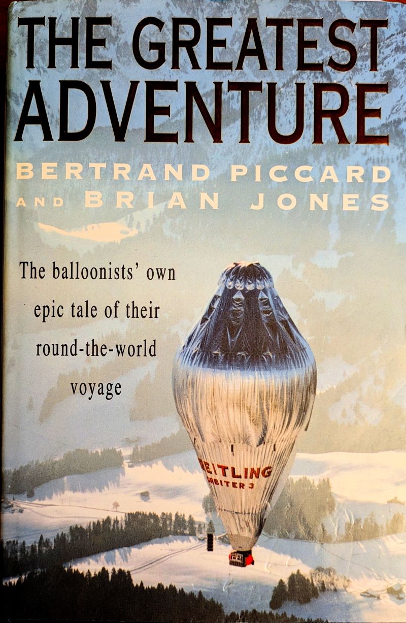 Picture of colour pictorial book cover showing silver coloured Rozier balloon bearing Breitling logo in red flying above snow covered landscape